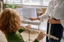 Child with red hair playing flute