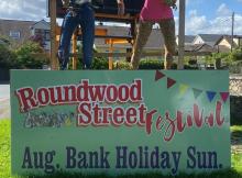 Two scarecrows at festival and sign Roundwood Street Festival